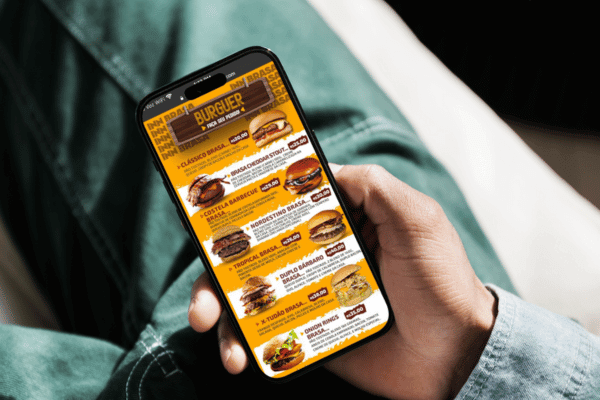 Uma pessoa segurando um telefone que na tela aparece um cardápio digital